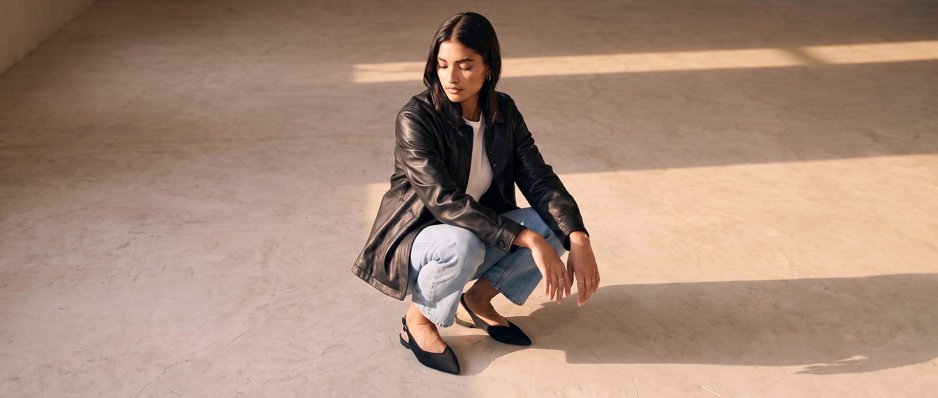 A relaxed everyday look featuring ALBA Minuit with light blue jean, a white tee-shirt and a black leather jacket. An effortless silhouette designed for daily comfort.